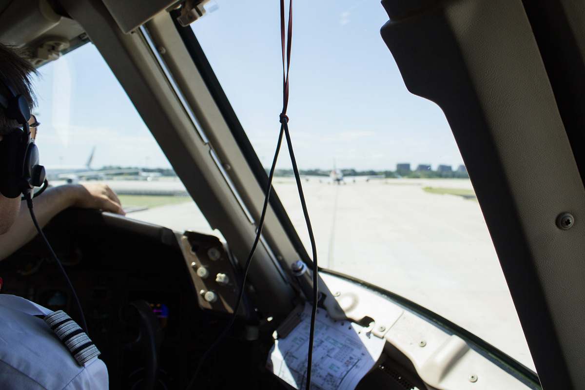 new york pilot wearing black headset inside aircraft with glass windshield united states
